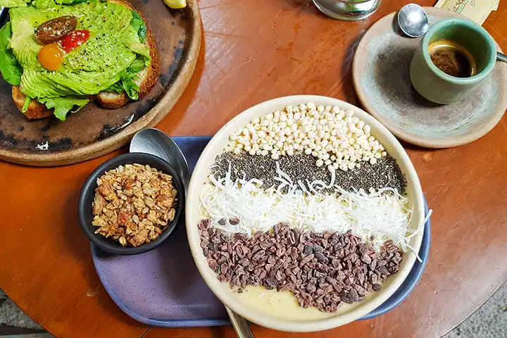 A table set with a bowl and a plate showing a typical breakfast and brunch in Holbox.
