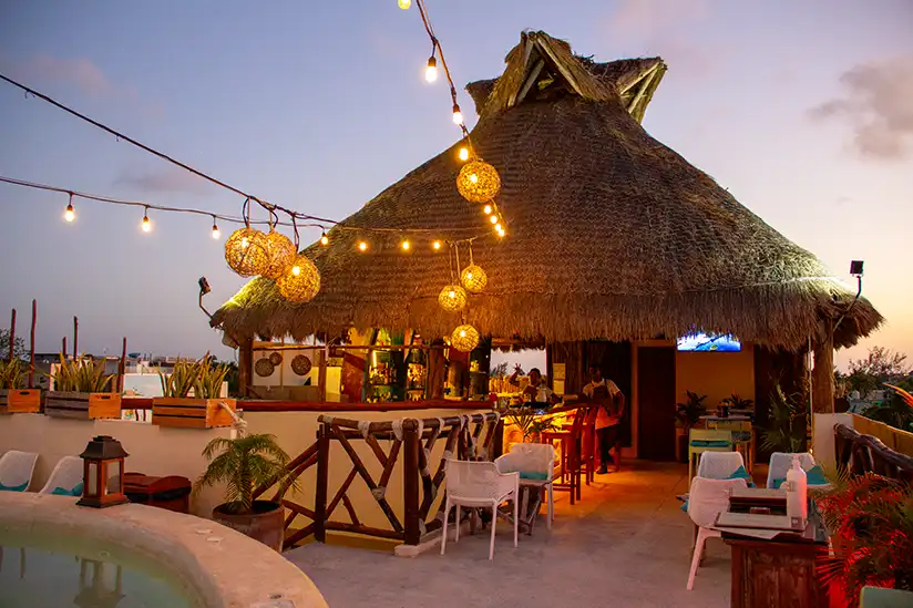 Thatched-roof bar arena in Holbox, decorated with lights that create a cozy atmosphere.