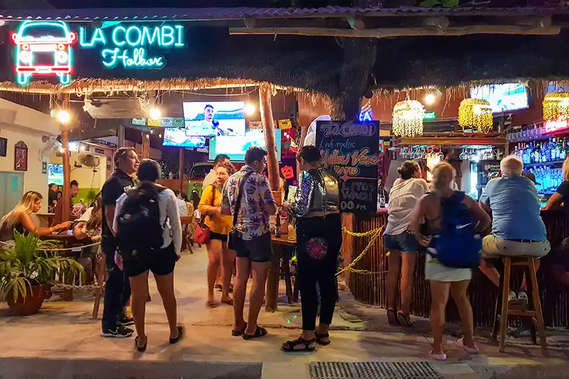 People stand in front of the Bar La Combi Holbox at night.