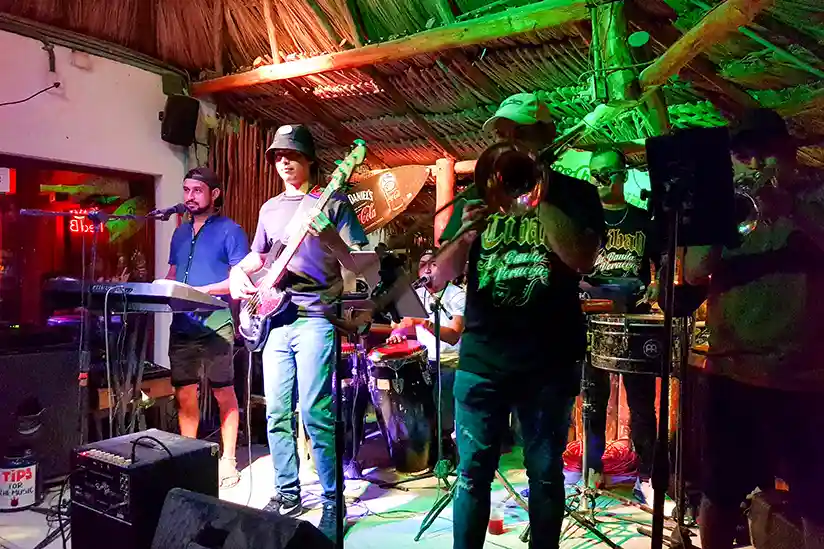 A band plays live music in the best Holbox bar while guests enjoy the nightlife in Holbox.