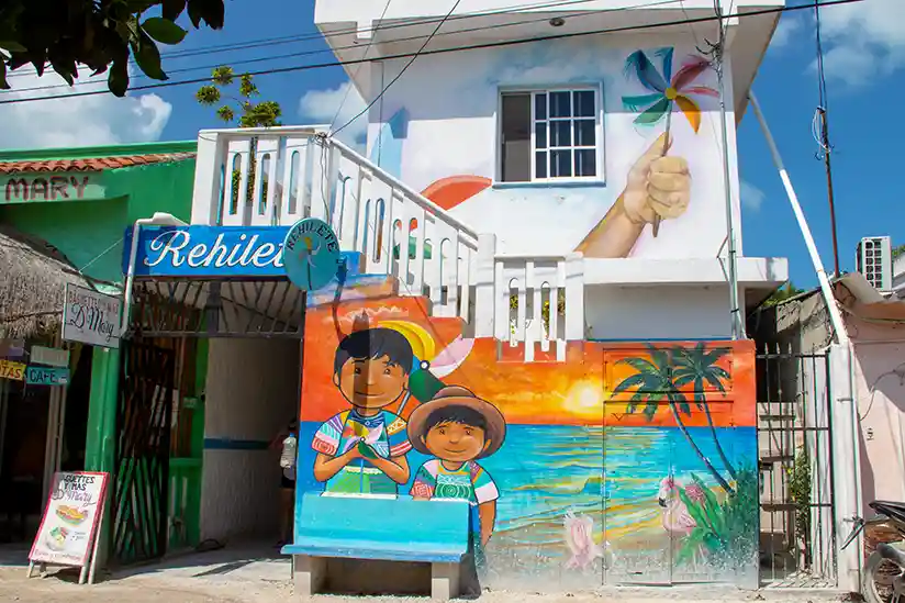 Das Gebäude mit bunter Wandmalerei von Estudios Rehilete in Holbox