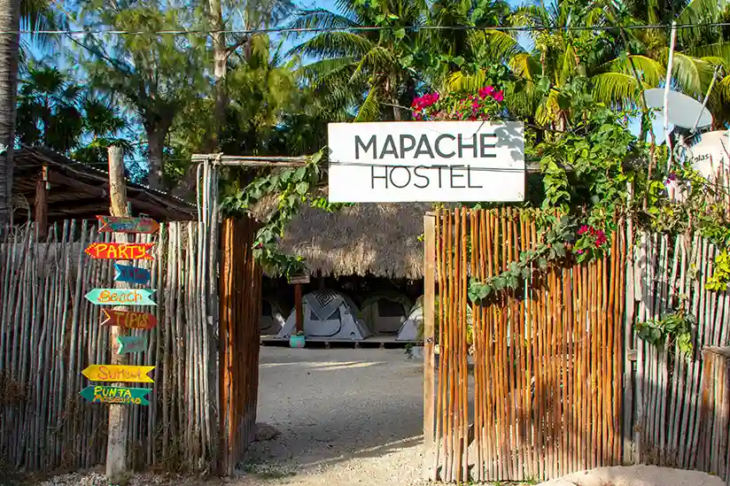The entrance with wooden fence to Mapache Hostel & Camping.