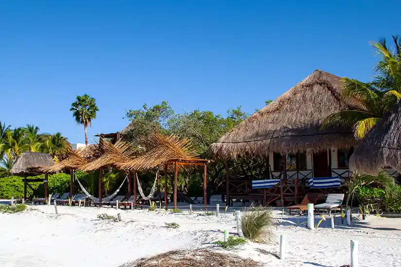 Beach area with sun loungers and hammocks at the Holbox Hotel Casa Takywara.
