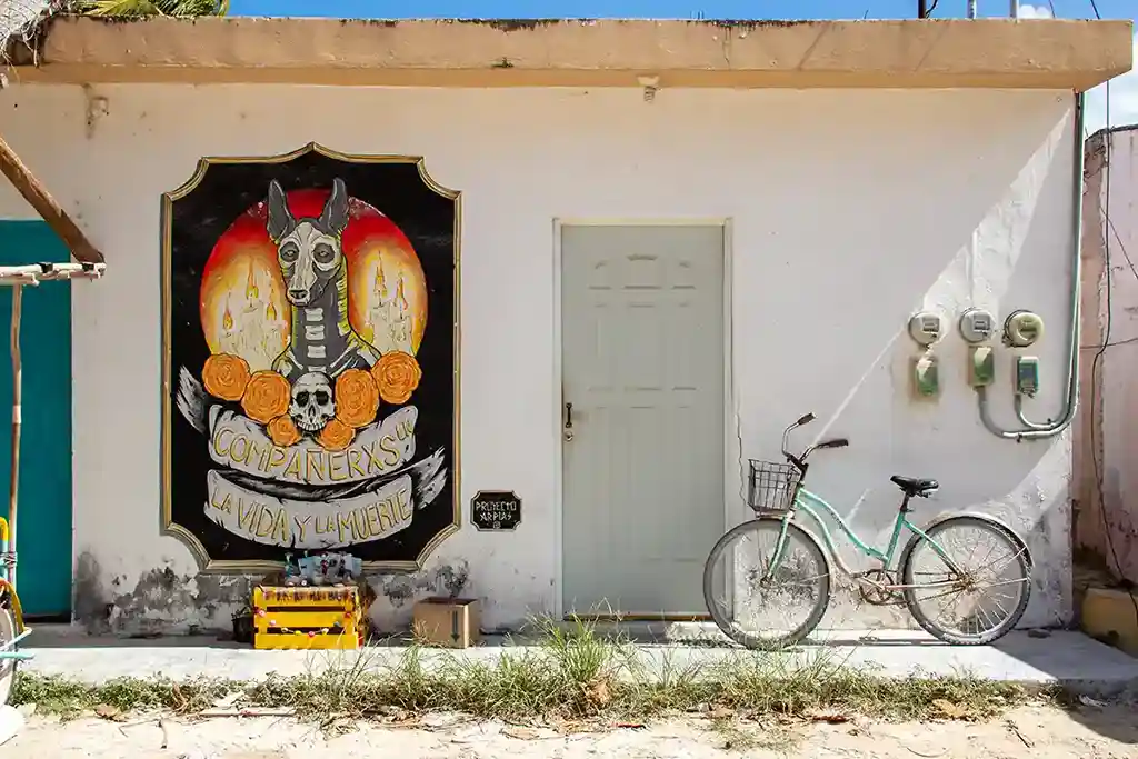 Day of the Dead inspired mural featuring a skeleton dog and Spanish festive lettering.