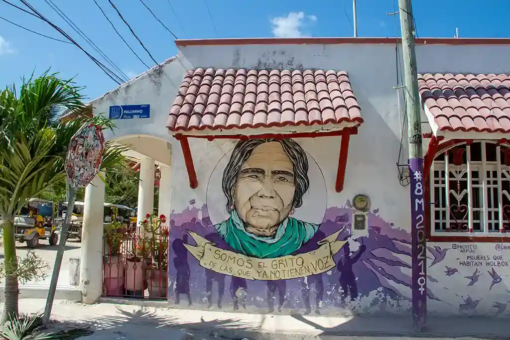 Meaningful mural on Holbox supporting women's rights with the text 'Somos el grito de las que ya no tienen voz'.