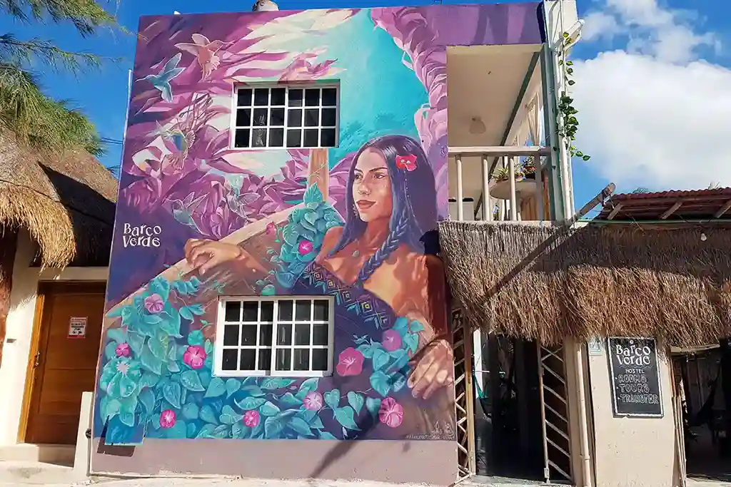 Beautiful street art mural of a woman with flowers at Hostel Barco Verde on Isla Holbox.