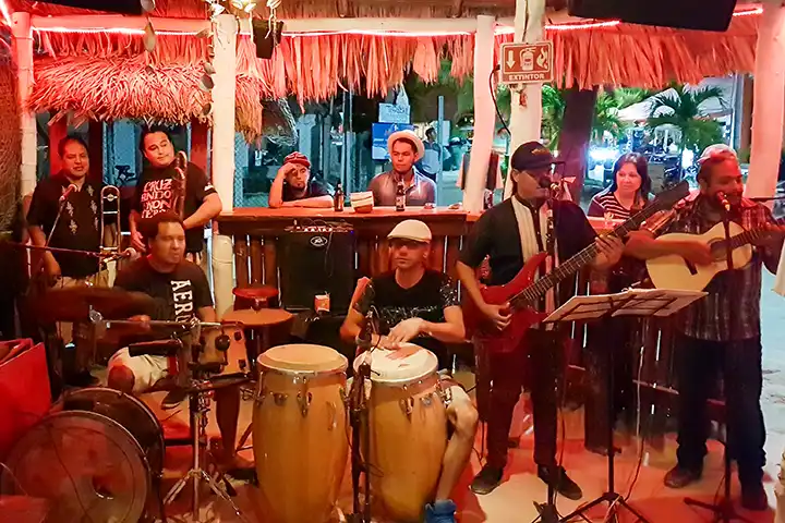 Eine Live-Band spielt mit Schlagzeug und Gitarren in der berühmten Hot Corner Bar auf Isla Holbox.