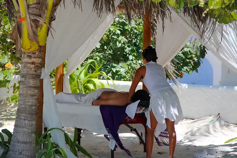 Relaxing wellness massage in the tranquil palm garden of a hotel on Isla Holbox.