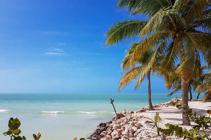 Holzkreuz am wilden Strandabschnitt nahe Punta Cocos auf Isla Holbox, der an historische Piraten erinnert.