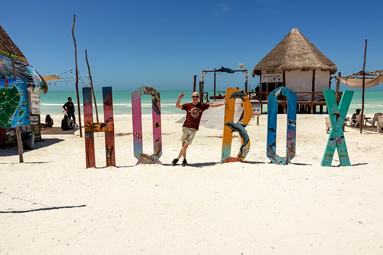 Christian zwischen den bunten HOLBOX-Buchstaben auf Isla Holbox.